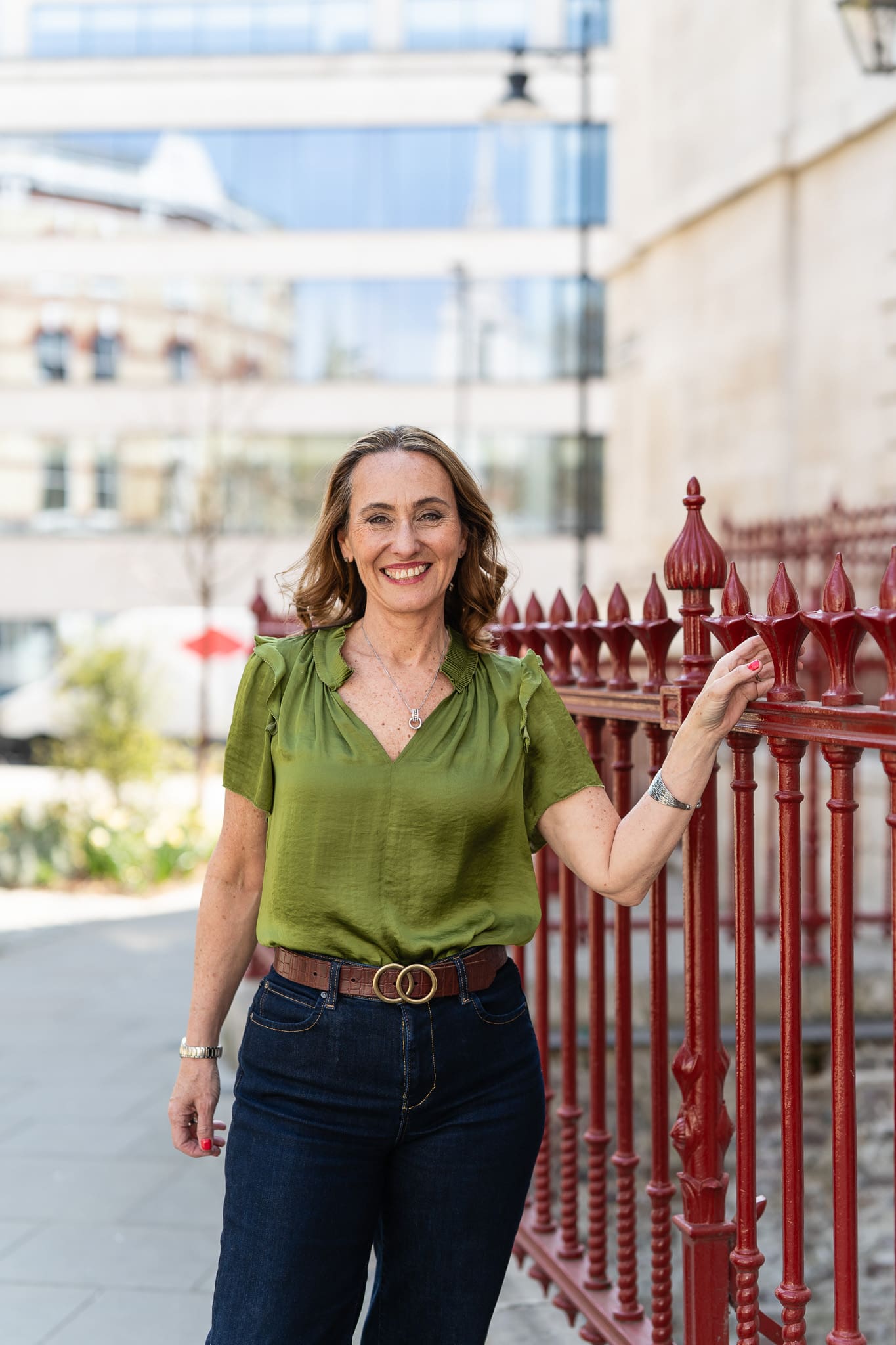 woman in green top and dark blue jeans on the street