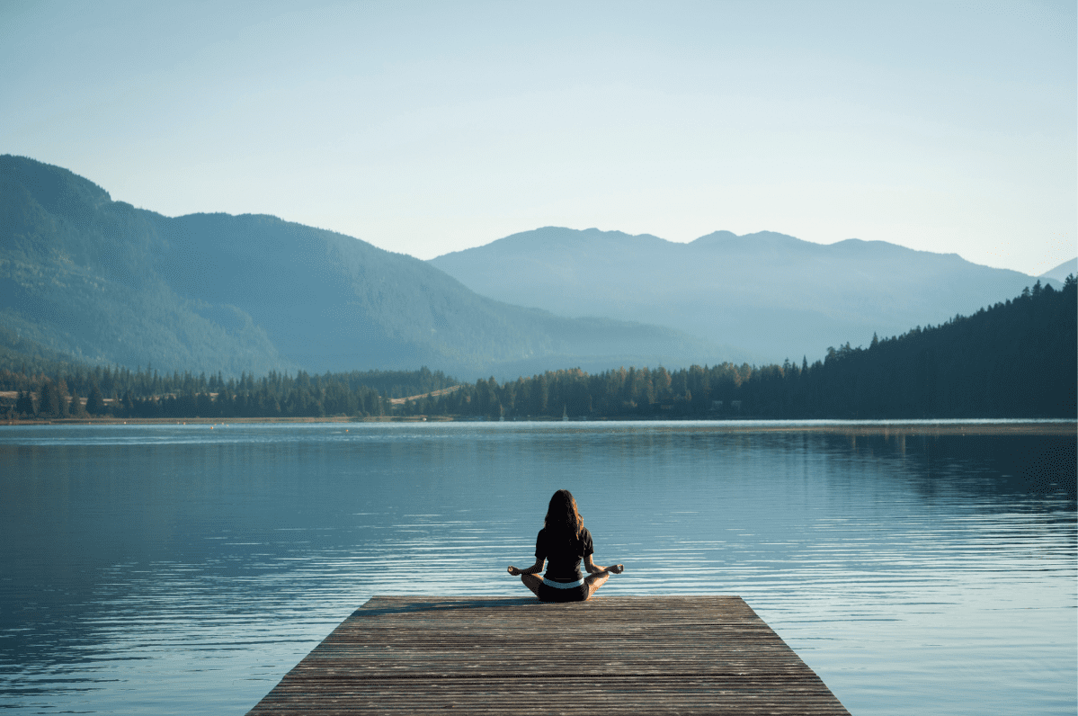 women meditating lake